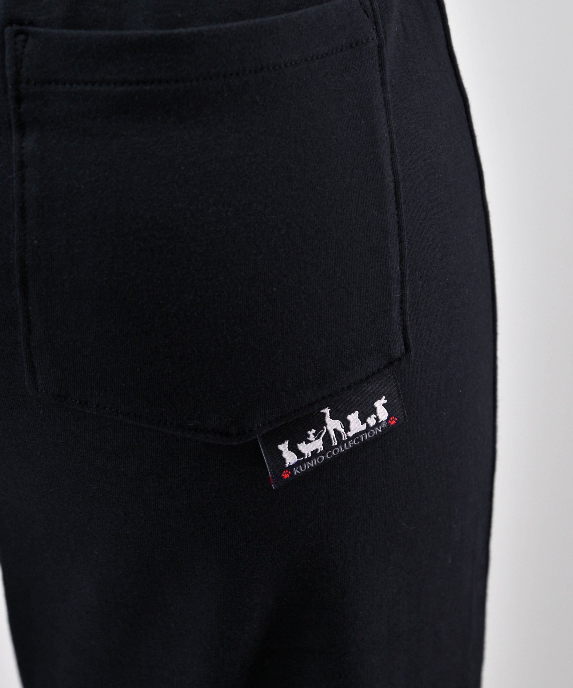 クニオコレクション(KUNIO COLLECTION)のクールUVガードストレッチパンツ(ロング)。UVカット機能と接触冷感素材を採用し、締め付け感を抑えた快適な履き心地のブラックカラーパンツ。ヒップポケットにあしらわれた可愛いワンちゃんのイラストがワンポイントで、かかとの高い靴にも合わせやすい股下ロング丈のボトムス。