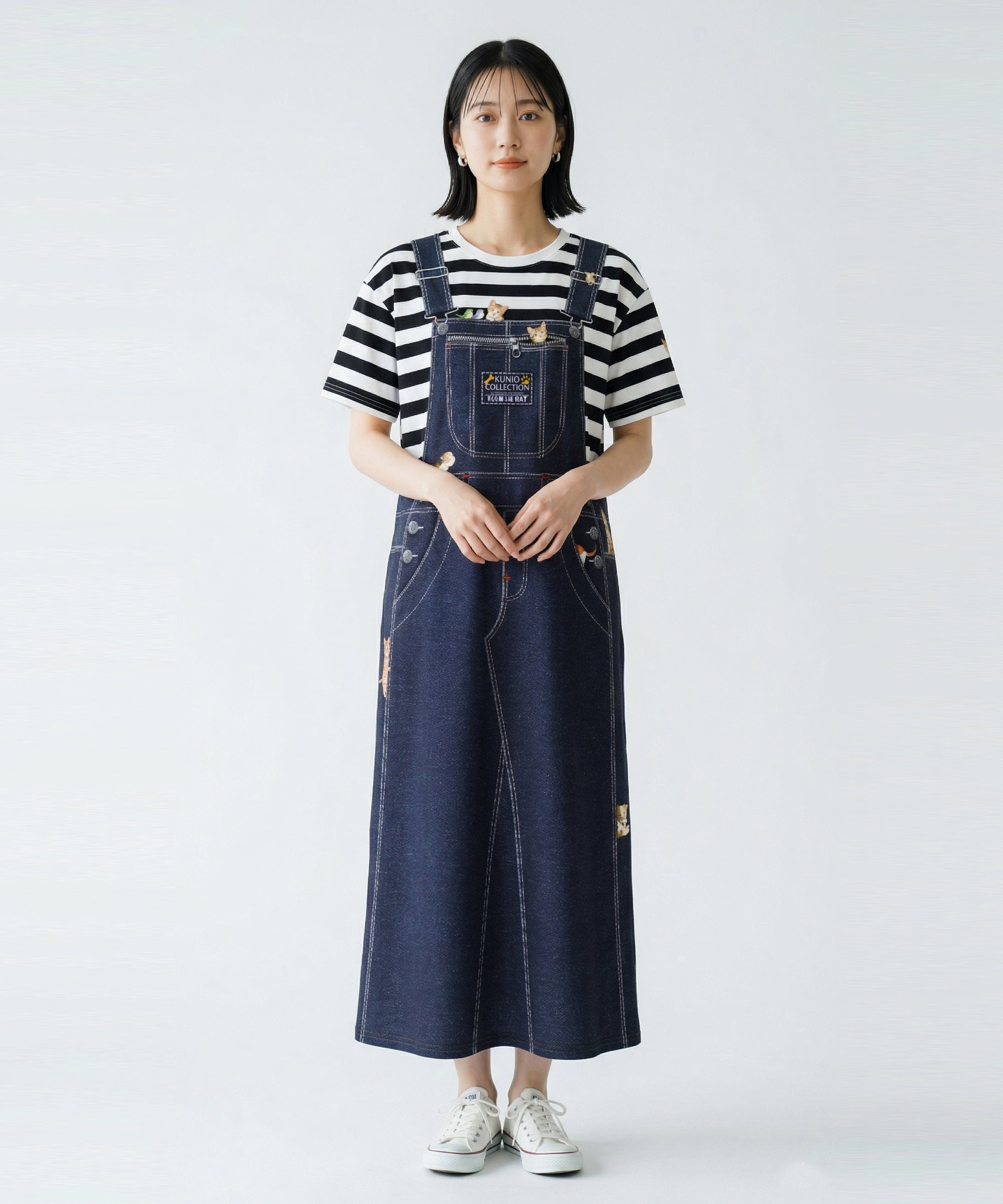 クニオコレクション(KUNIO COLLECTION)のデニムジャンスカビッグワンピース(ネコ)。大きなフェイクオーバーオール風のだまし絵プリントが特徴の、美しいフレアシルエットの一枚。ネイビーデニムに愛らしいネコちゃん柄があしらわれたお茶目で楽しいデザインのワンピース。