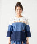 クニオコレクション(KUNIO COLLECTION)のスリーステップ(ネコ)ドルマンTシャツ。バイカラーデニム風のデザインに愛らしいネコちゃん柄をあしらった、ゆるっとオフボディなシルエットの一枚。さらりとした軽い着心地と心地よいストレッチ素材が特徴のトップス。