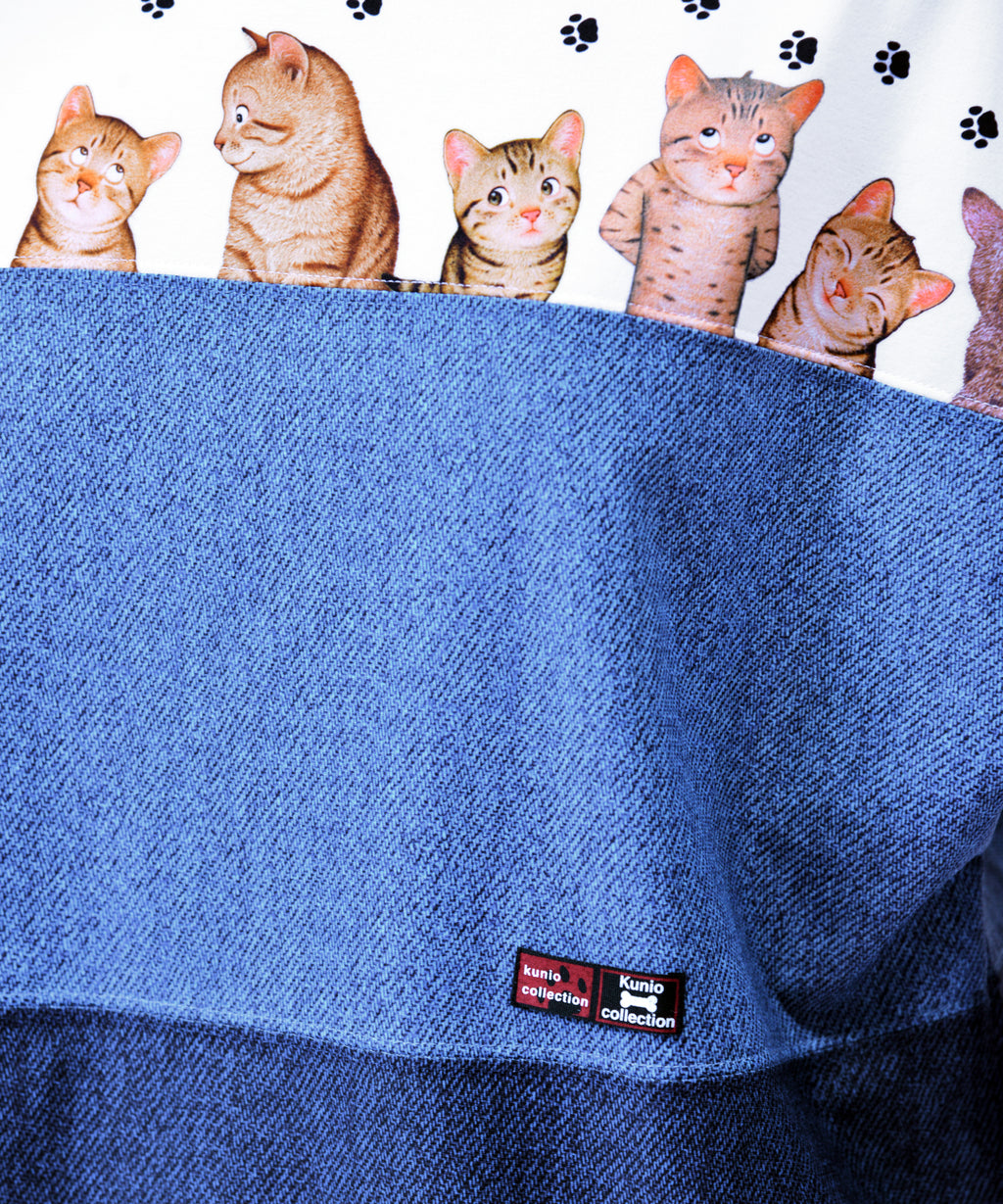 クニオコレクション(KUNIO COLLECTION)のスリーステップ(ネコ)ドルマンTシャツ。バイカラーデニム風のデザインに愛らしいネコちゃん柄をあしらった、ゆるっとオフボディなシルエットの一枚。さらりとした軽い着心地と心地よいストレッチ素材が特徴のトップス。