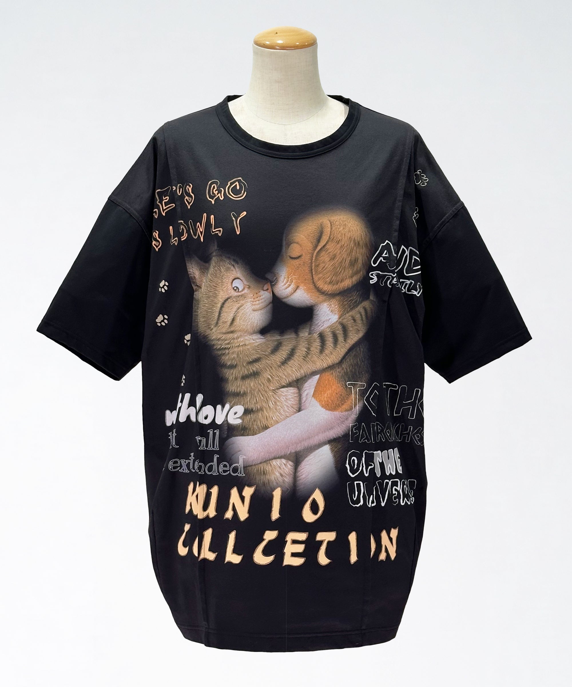 クニオコレクション(KUNIO COLLECTION)のタックT(ブラック)。ロミオとジュリエットをテーマにした可愛いネコちゃんとワンちゃんの作品をストリート調にデザインしたTシャツ。「LET’S GO SLOWLY, AND STEADILY（ぼちぼちいこか）」のメッセージを配し、さらりとした軽い着心地と気持ちの良いストレッチ性を備えた異形糸使用のトップス。