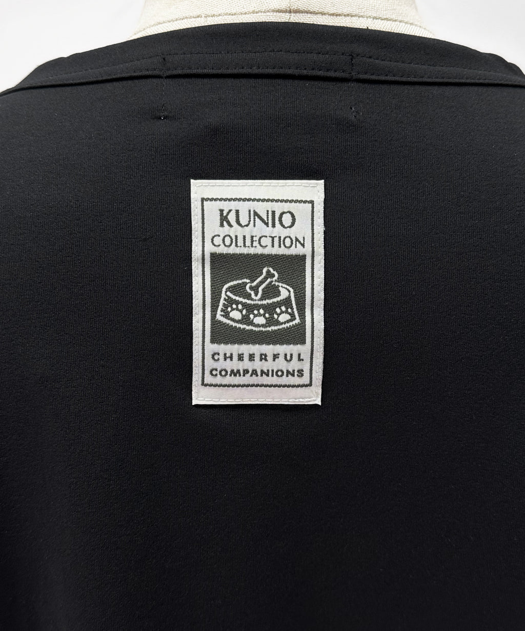 クニオコレクション(KUNIO COLLECTION)のタックT(ブラック)。ロミオとジュリエットをテーマにした可愛いネコちゃんとワンちゃんの作品をストリート調にデザインしたTシャツ。「LET’S GO SLOWLY, AND STEADILY（ぼちぼちいこか）」のメッセージを配し、さらりとした軽い着心地と気持ちの良いストレッチ性を備えた異形糸使用のトップス。