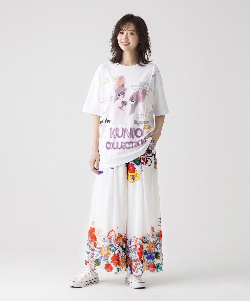 クニオコレクション(KUNIO COLLECTION)のチュールスカパンツ(アート)。ふんわり軽やかなチュール素材を二重に使用し、一見スカートのように見える上品なワイドパンツ。華やかなボタニカル柄に可愛いアニマルたちが見え隠れするデザインで、箱タックがお腹周りをすっきりと見せるボトムス。